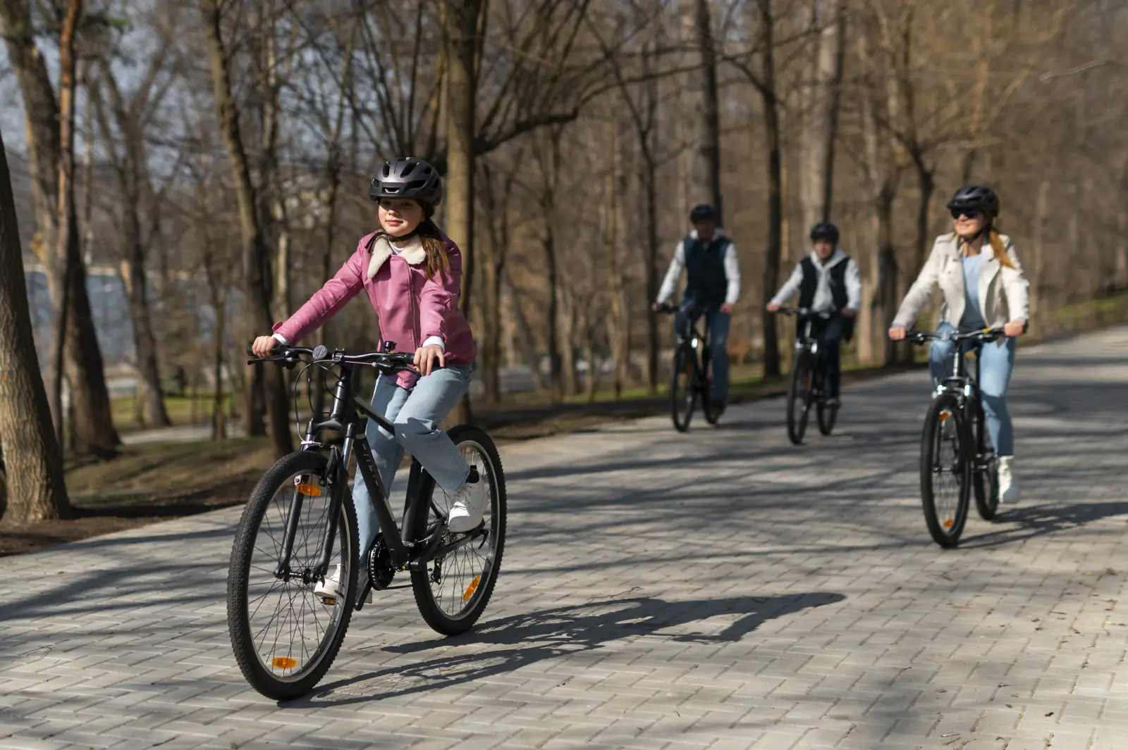 Family cycling together along a tree-lined path in Stockholm