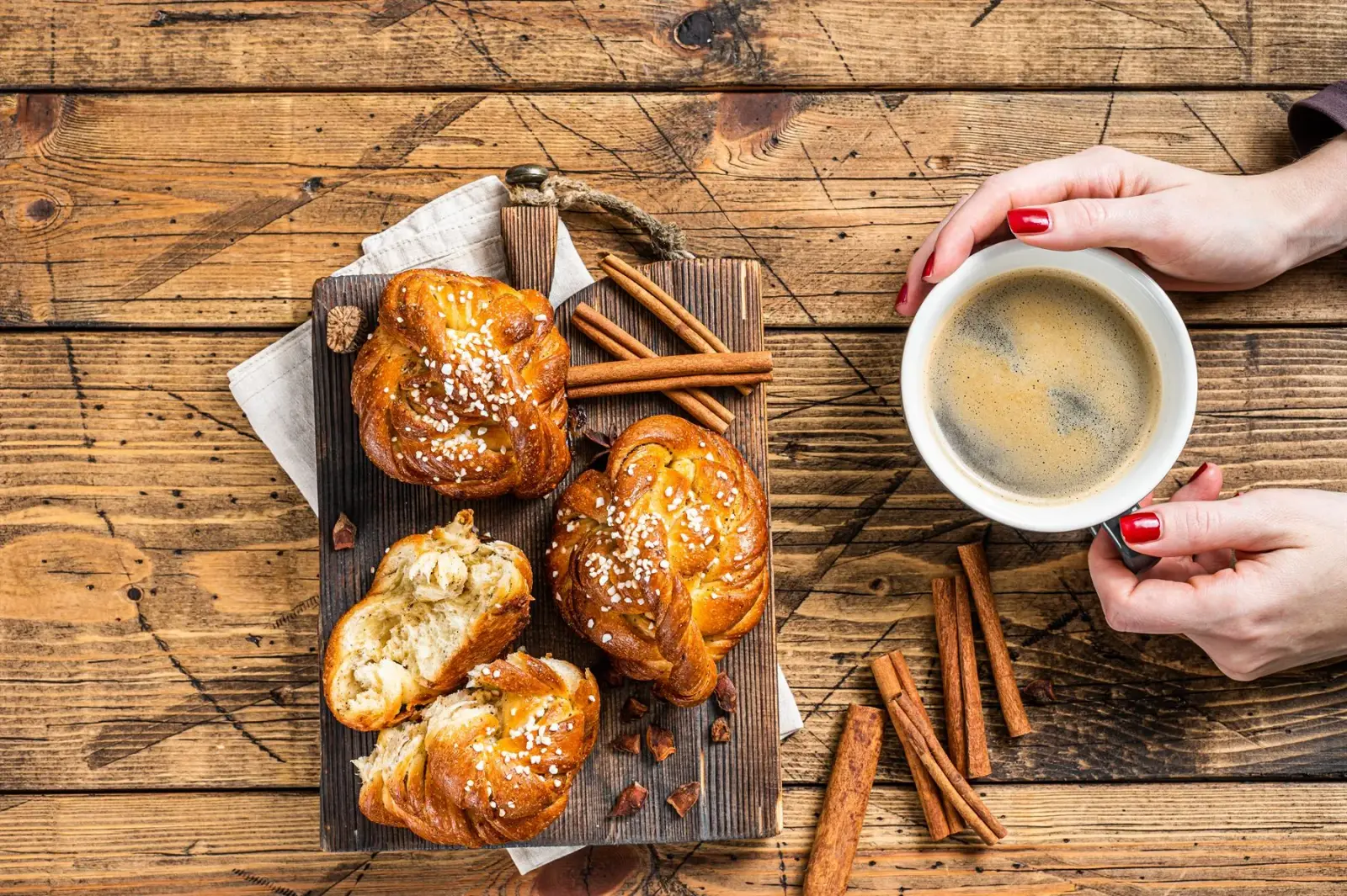 Coffee and cinnamon buns served on a rustic wooden table