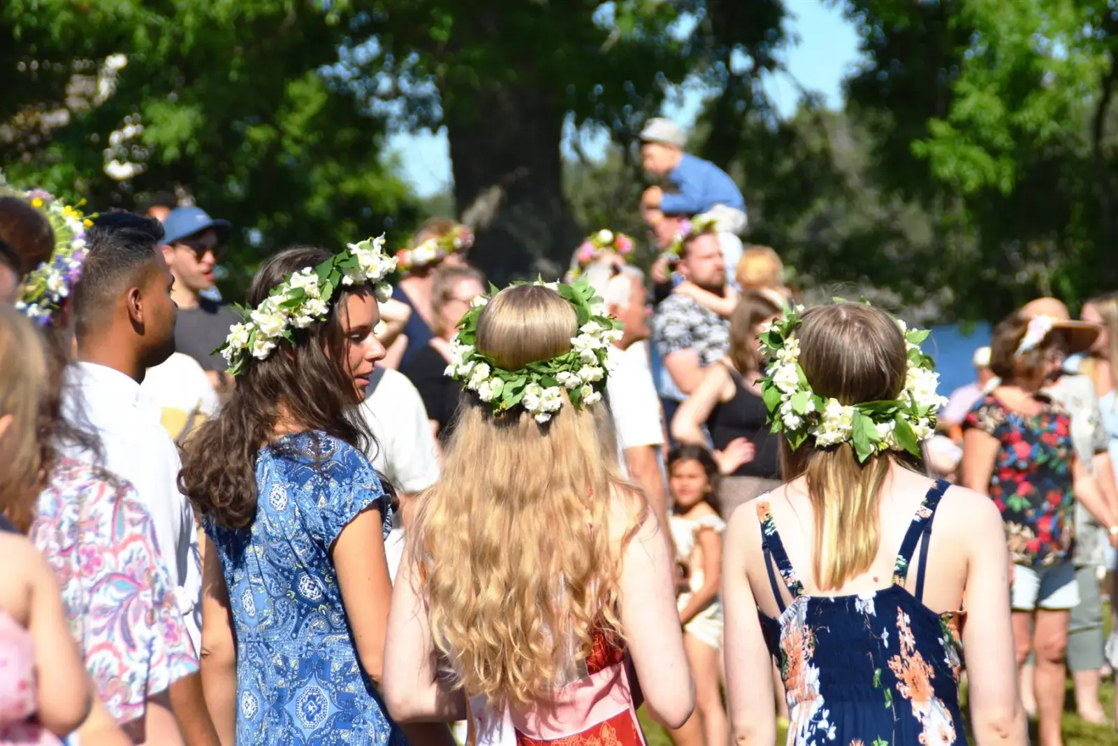 People wearing flower crowns at an outdoor Midsommar celebration in Sweden