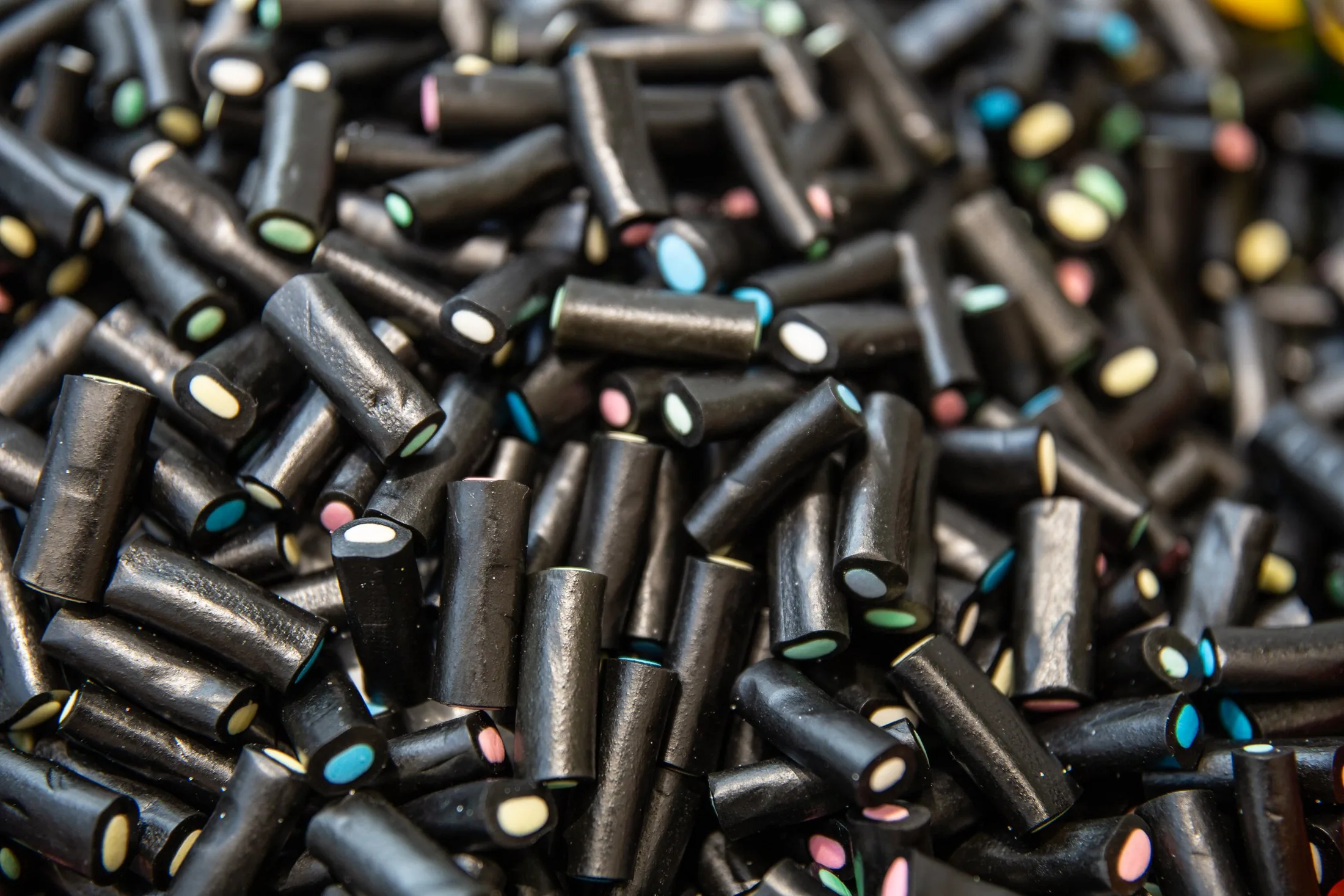 Pile of black licorice candies with colorful centers