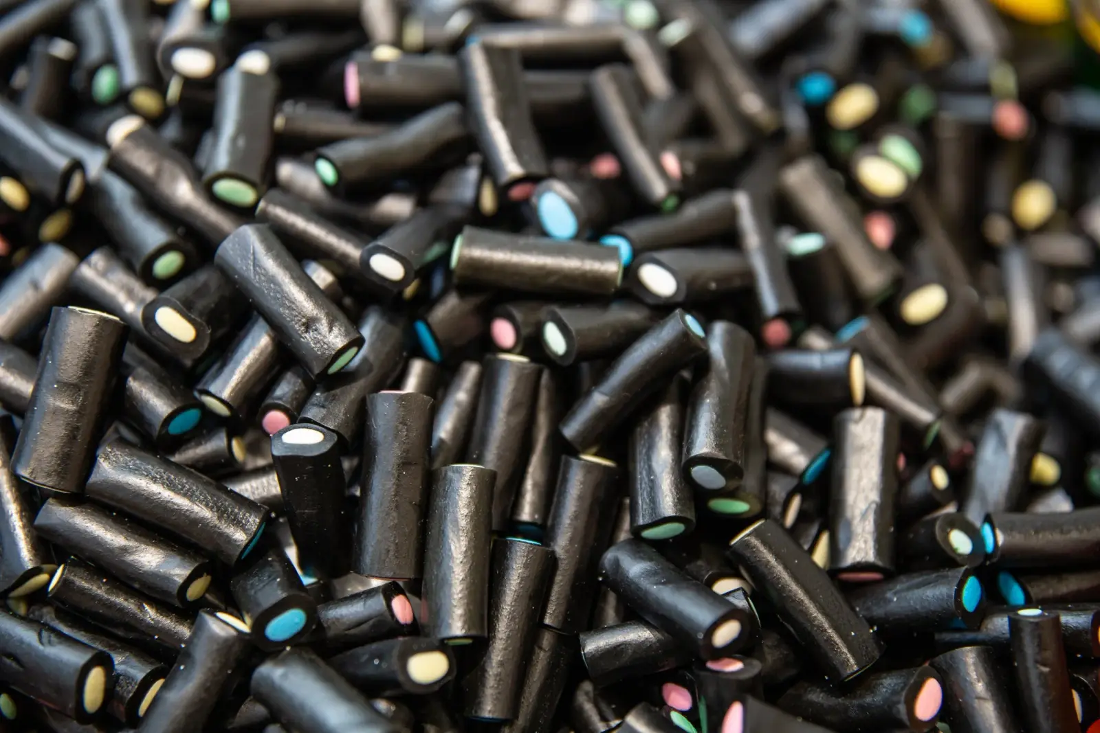 Pile of black licorice candies with colorful centers