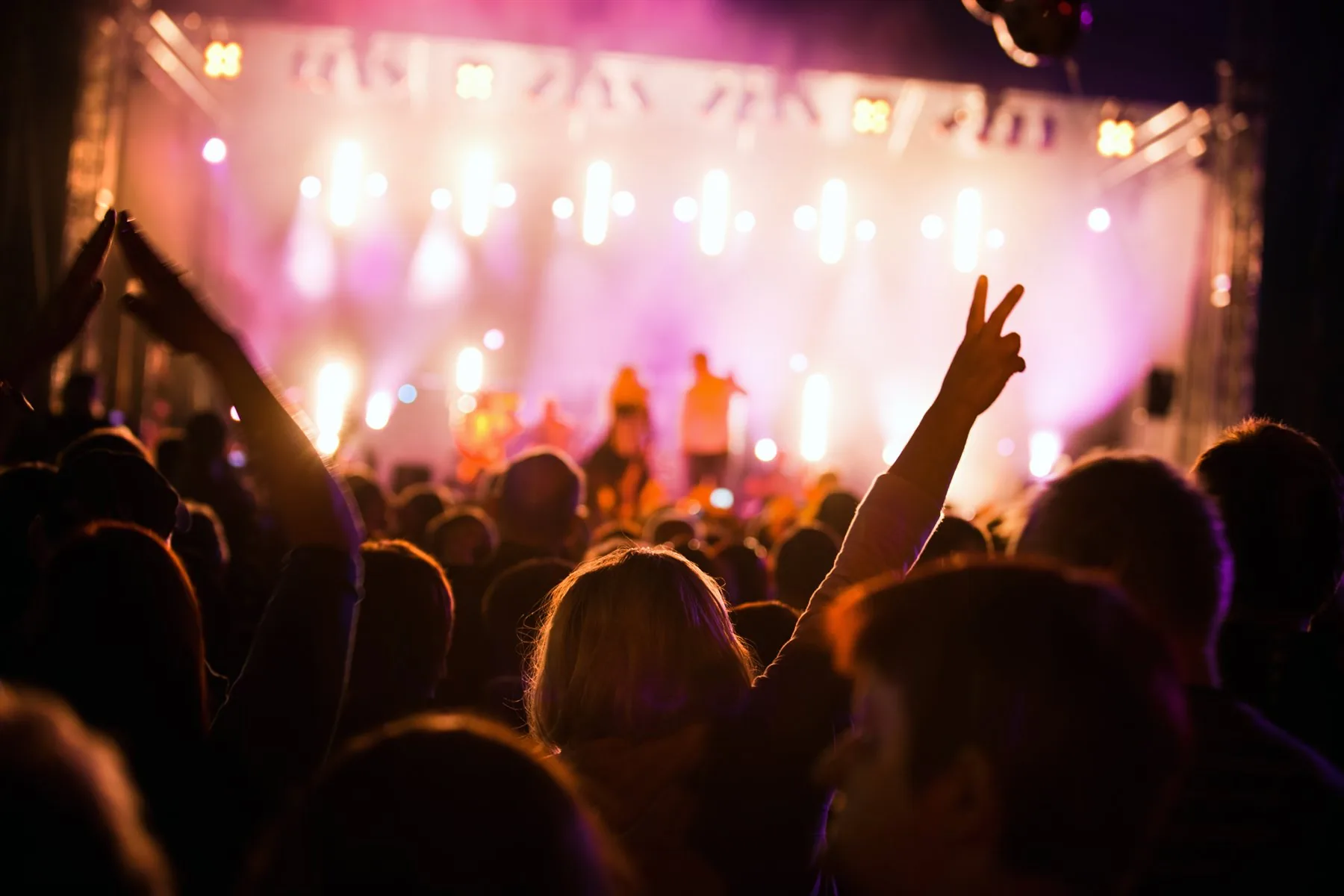 Crowd facing a brightly lit concert stage during a live music event