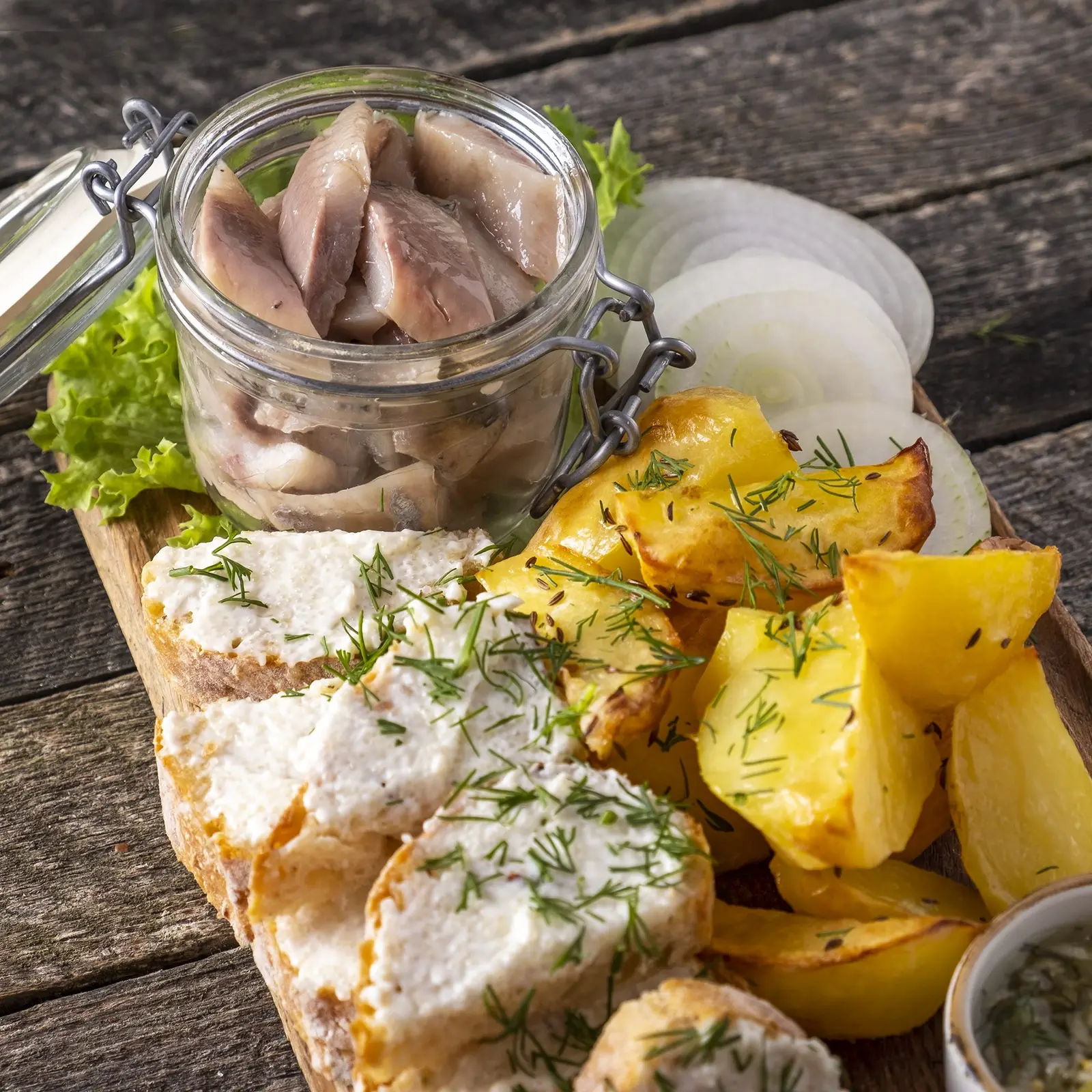 Pickled herring with potatoes, onion, crispbread, and dill for a Swedish Midsommar meal
