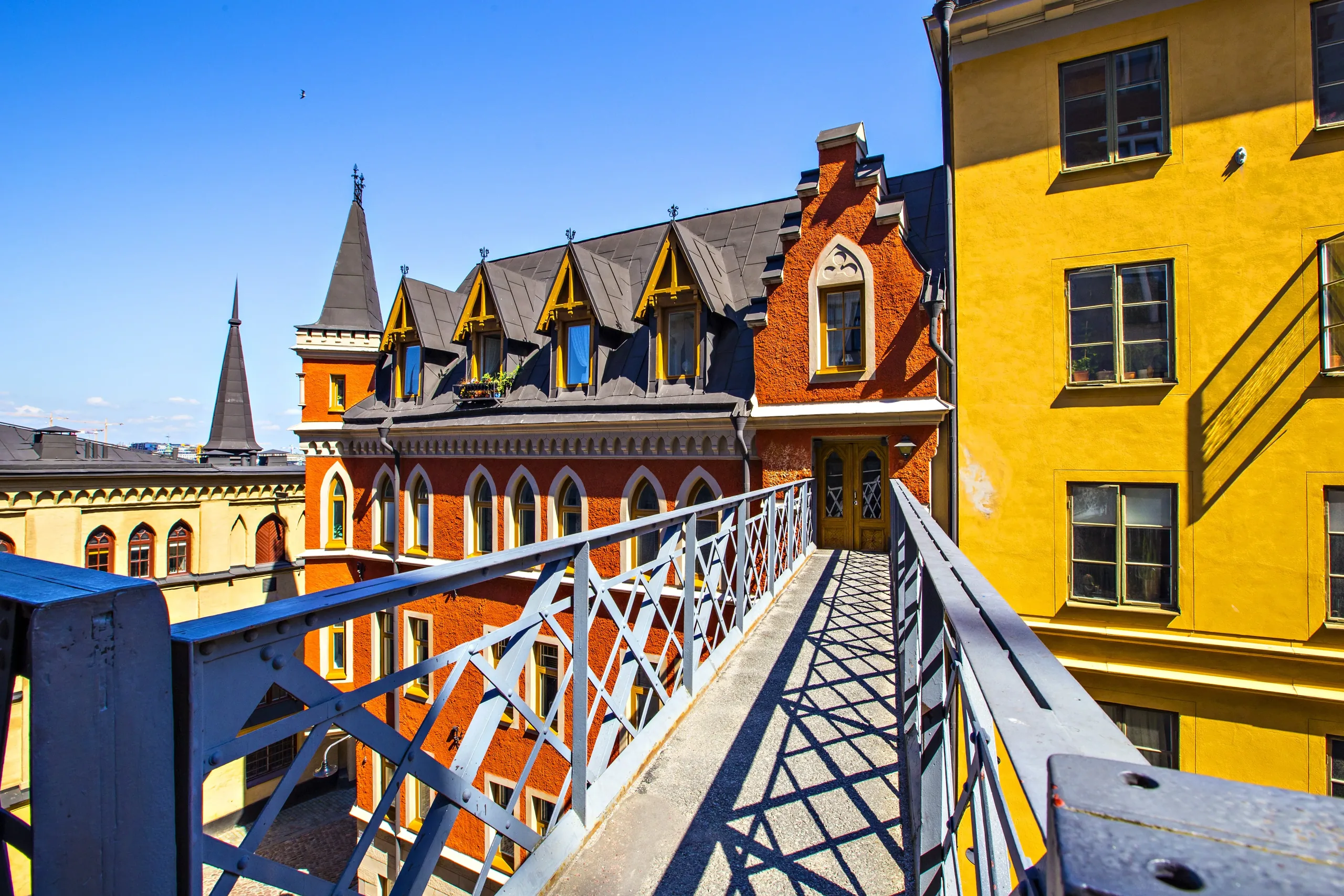 Walkway view beside a vivid orange historic building in Södermalm