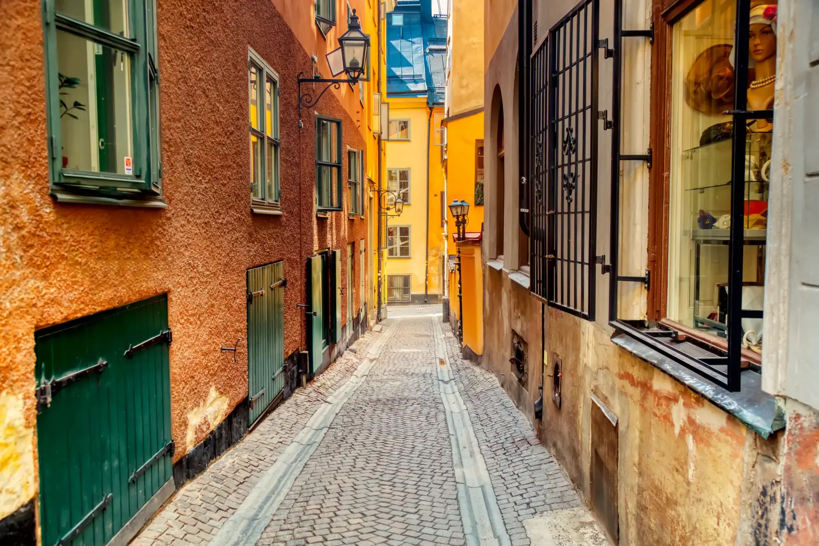 Warm-toned cobblestone alley in Gamla stan lined with narrow historic buildings