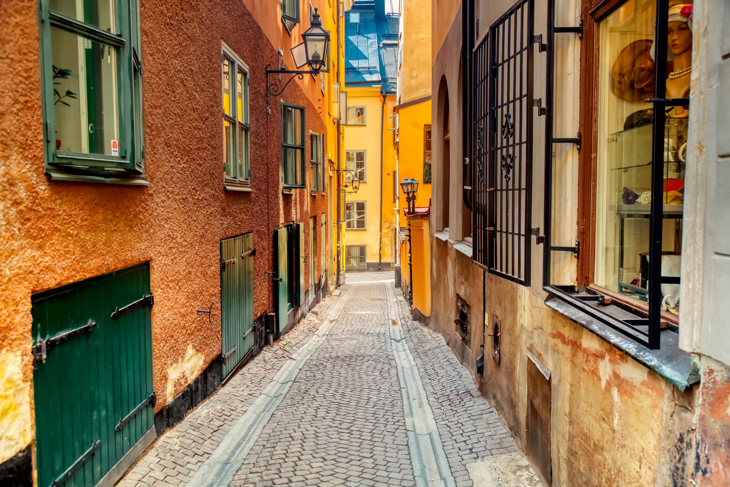 Warm-toned cobblestone alley in Gamla Stan lined with narrow historic buildings