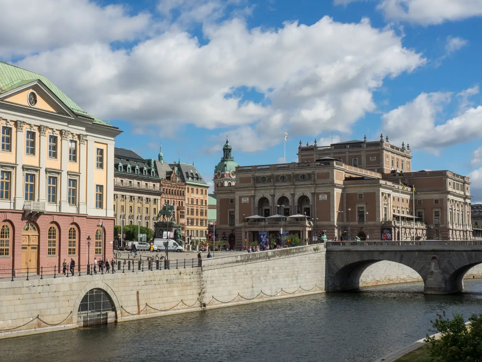 Royal Opera building and bridge along the Stockholm waterfront under a bright blue sky